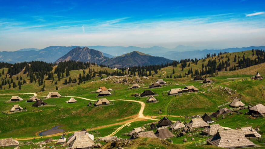 Mountain village in Alps, wooden houses in traditional style, Velika Planina, Kamnik, Slovenia. Summer touristic destination background
