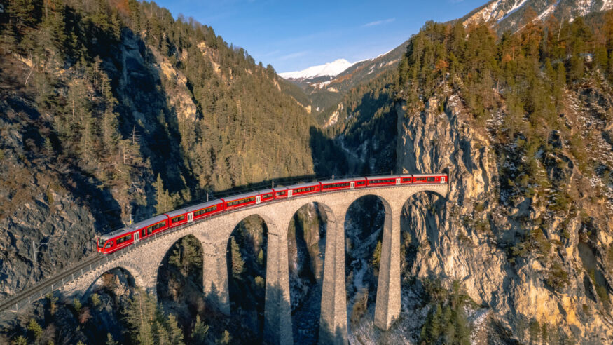 A train passing along the famous Landwasser railway, famous for the viaduct and beautiful scenery surrounding the railway in the Switzerland mountains