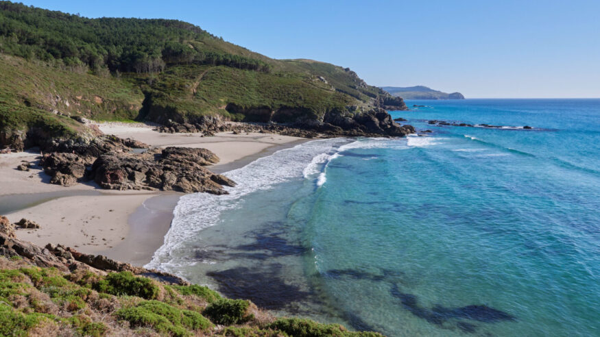 Costa da Morte beach on the Atlantic Ocean on a summer day with calm sea. This region of northern Spain is known for its unspoiled coastline and surfing waves.